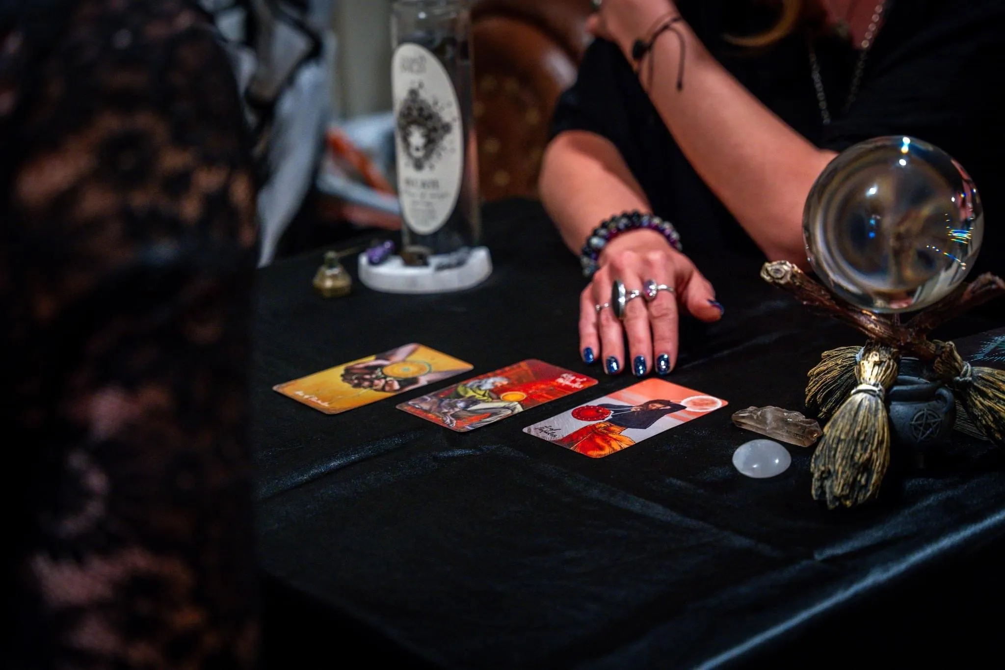 Cora laying out tarot cards across a candlelit table
