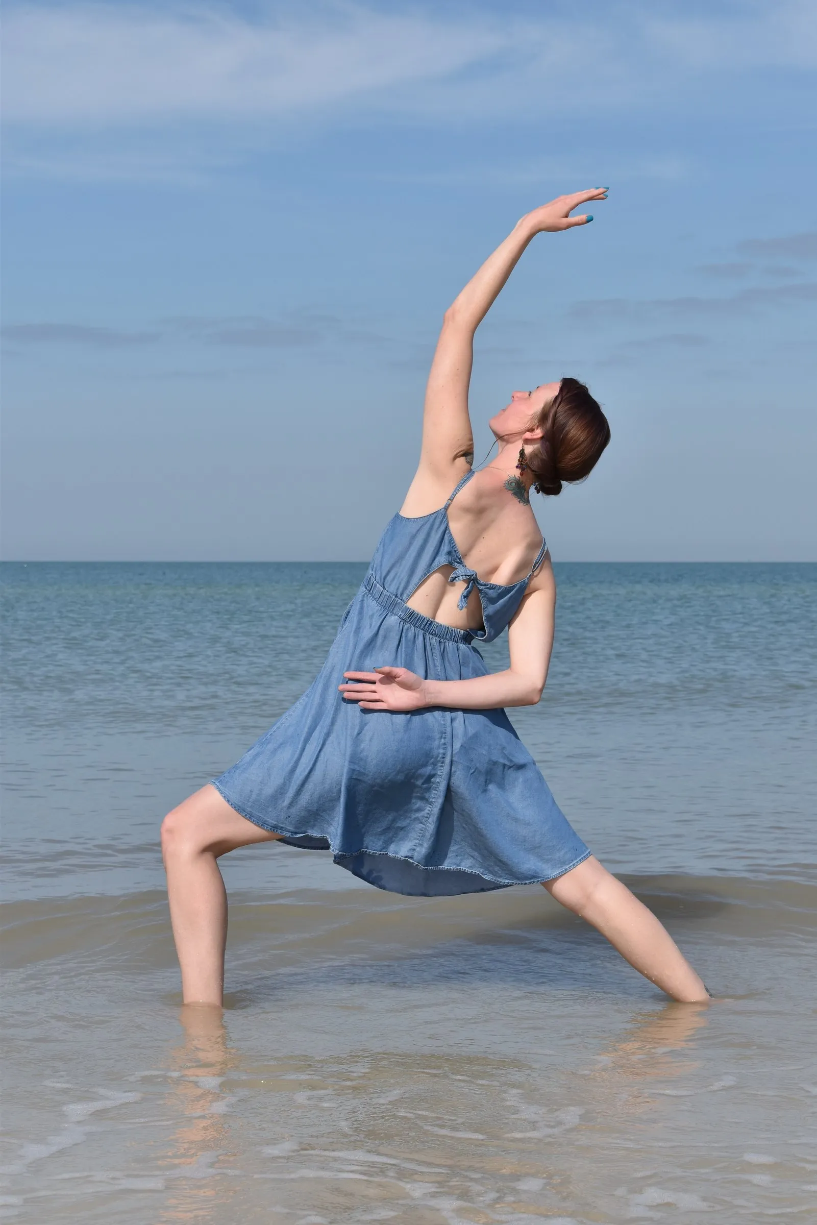 Cora dancing on the beach at the water's edge
